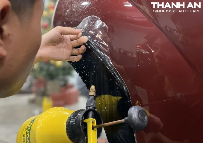 Chủ xe Kia Cadenza kiểm tra chất lượng phim bảo vệ sơn sau khi hoàn thiện.
