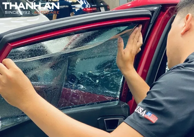 Kỹ thuật viên thi công dán phim cách nhiệt 3M cho xe BMW GT tại Quận 7