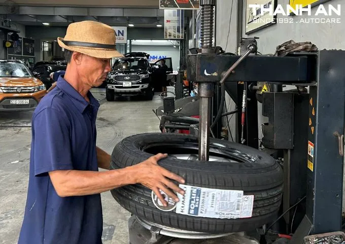 Kỹ thuật viên đang thay lốp ô tô Kia Sedona tại gara