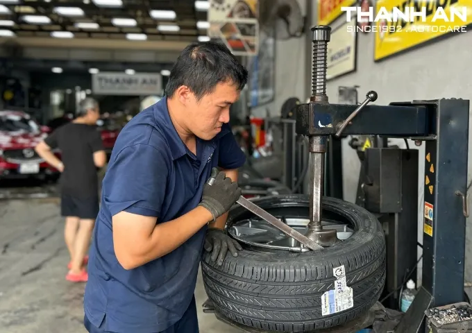 Kỹ thuật viên đang thay lốp xe Peugeot 508 tại gara