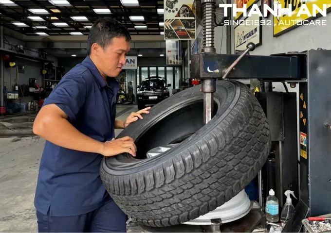 Kỹ thuật viên đang thay lốp xe Toyota Land Cruiser chính hãng tại gara