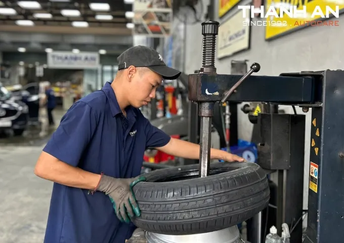 Kỹ thuật vi&ecirc;n đang th&aacute;o lốp xe Toyota Yaris cũ để thay mới