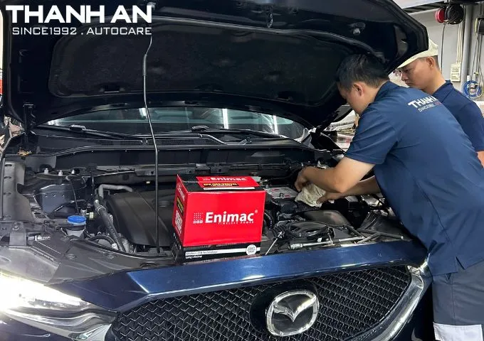 Kỹ thuật viên đang thay bình ắc quy xe ô tô tại gara
