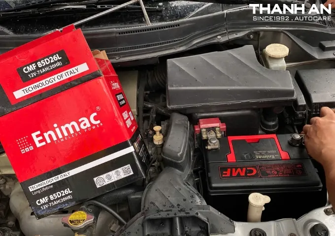 Kỹ thuật viên thay bình ắc quy Enimac CMF cho xe ô tô tại gara