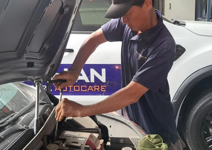 Kỹ thuật viên thay bình ắc quy Enimac cho xe ô tô Ford tại gara
