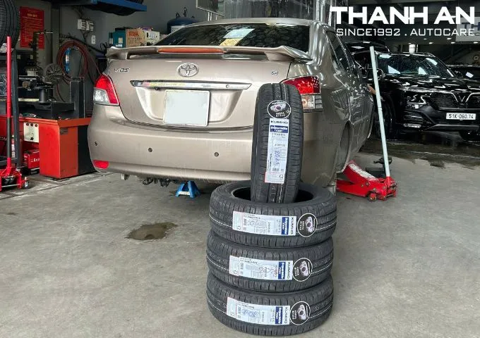Bốn lốp Kumho mới xếp cạnh xe ô tô trước khi lắp đặt