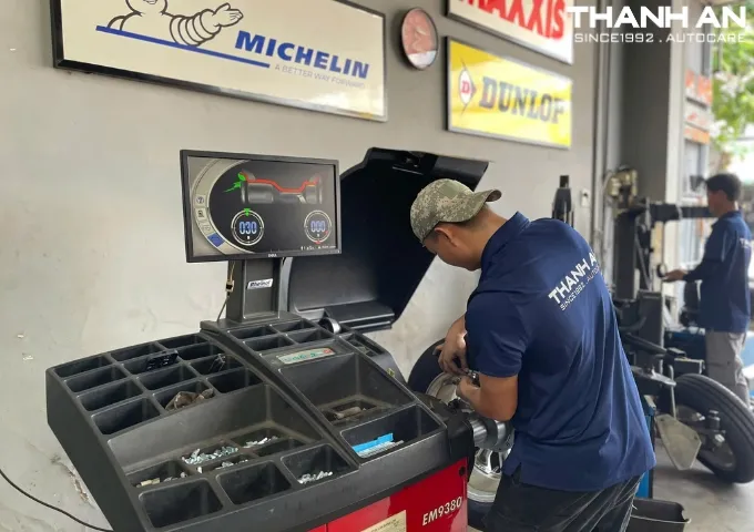 Kỹ thuật viên cân bằng động (cân mâm dán chì) lốp xe ô tô sau khi thay lốp mới